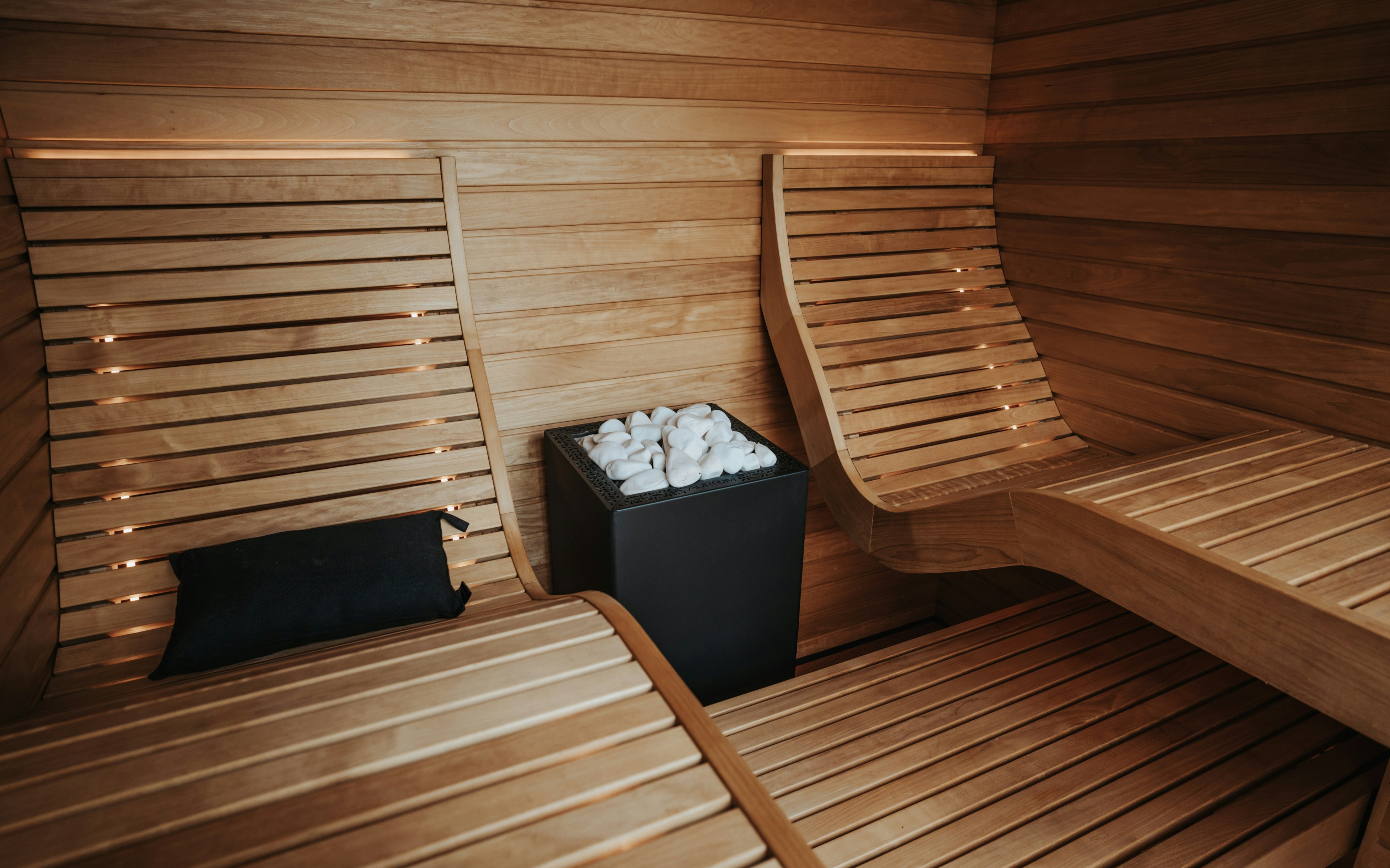 Interior modern de saună din lemn, cu bănci și sobă, conceput pentru relaxare și întinerire a pielii