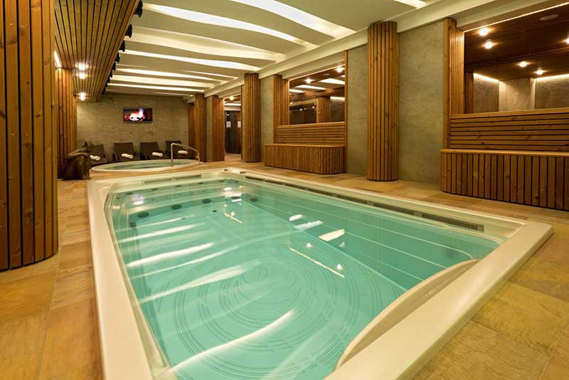 Spa de înot USSPA interior instalat într-o zonă de wellness cu o zonă separată de relaxare