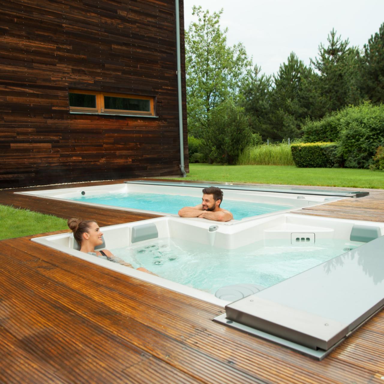 Cuplu relaxându-se în spa-ul USSPA în aer liber și piscinele spa instalate pe o terasă din lemn